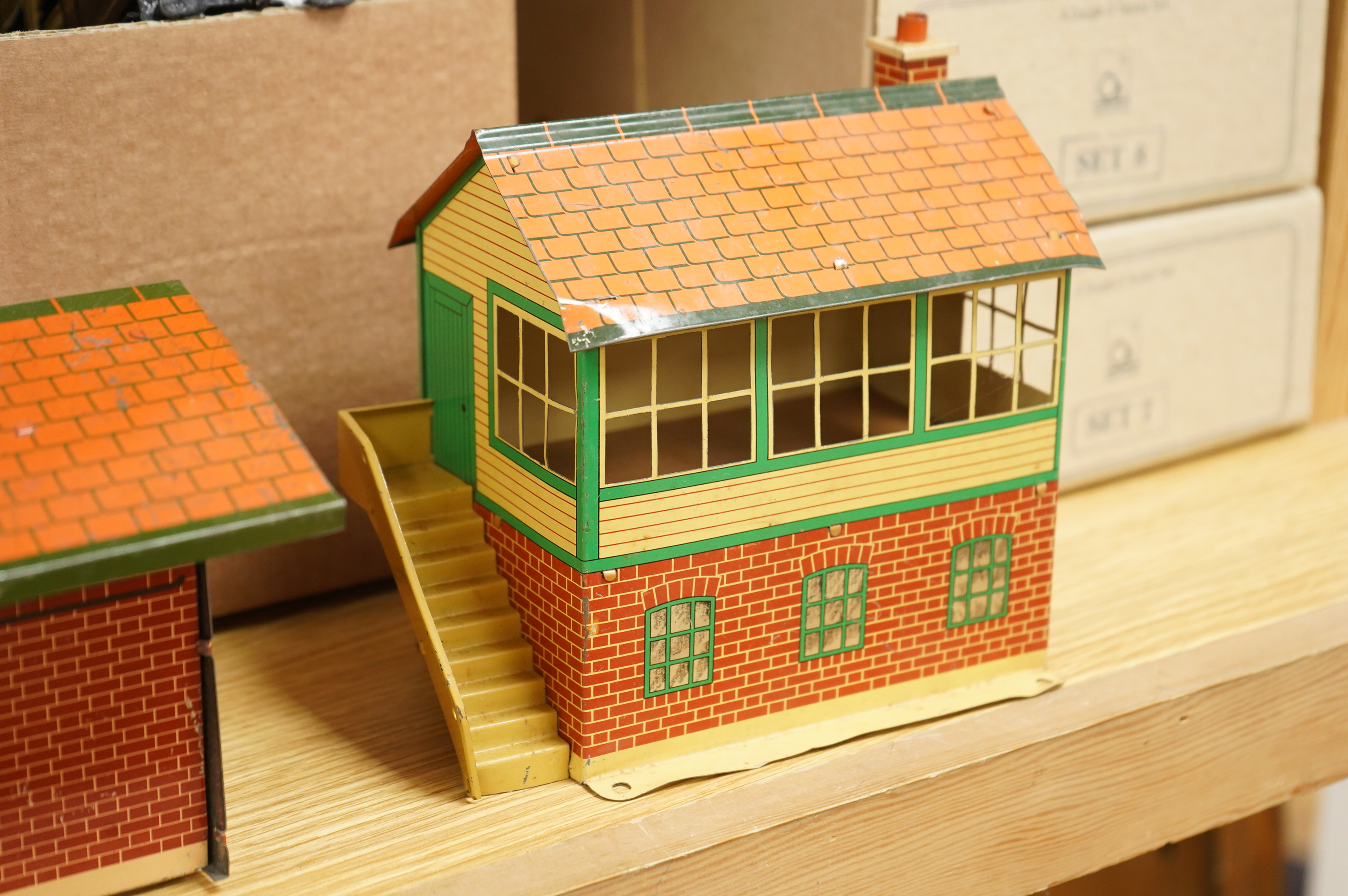 A collection of 0 gauge Hornby tinplate clockwork railway, including four BR locomotives, 17 freight wagons and four wheel coaches, together with a station building, signal cabin, and Goods depot (missing base), plus a f